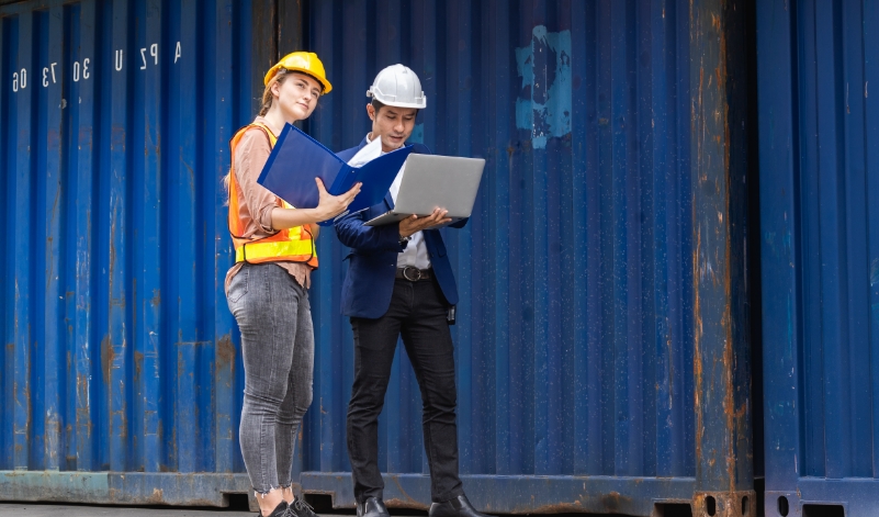 Cargo documentation being checked beside a shipping container
