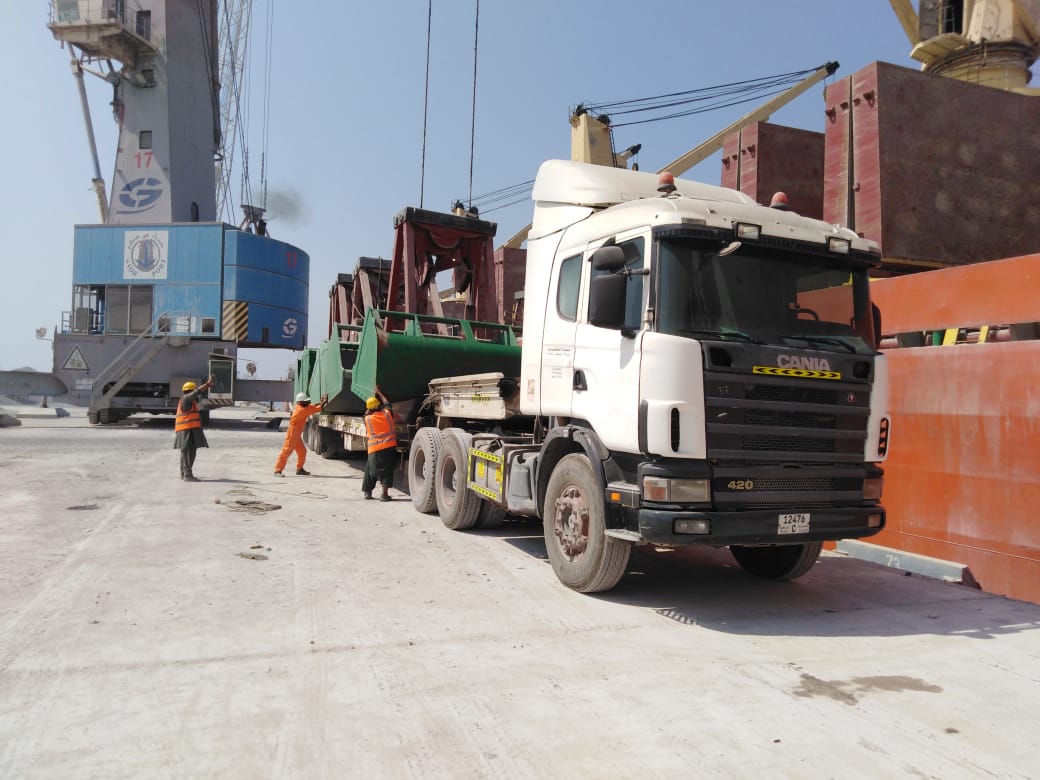 Truck and port personnel alongside a cargo vessel