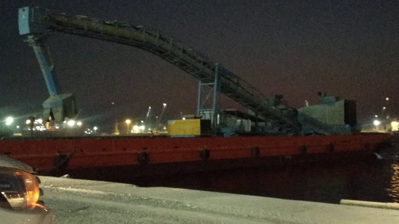 Cargo conveyor working above a vessel at night