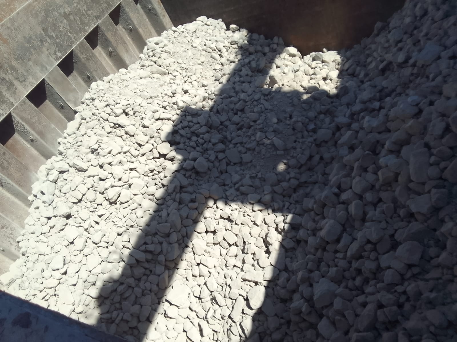 Bulk rock cargo beneath the open hatch of the vessel