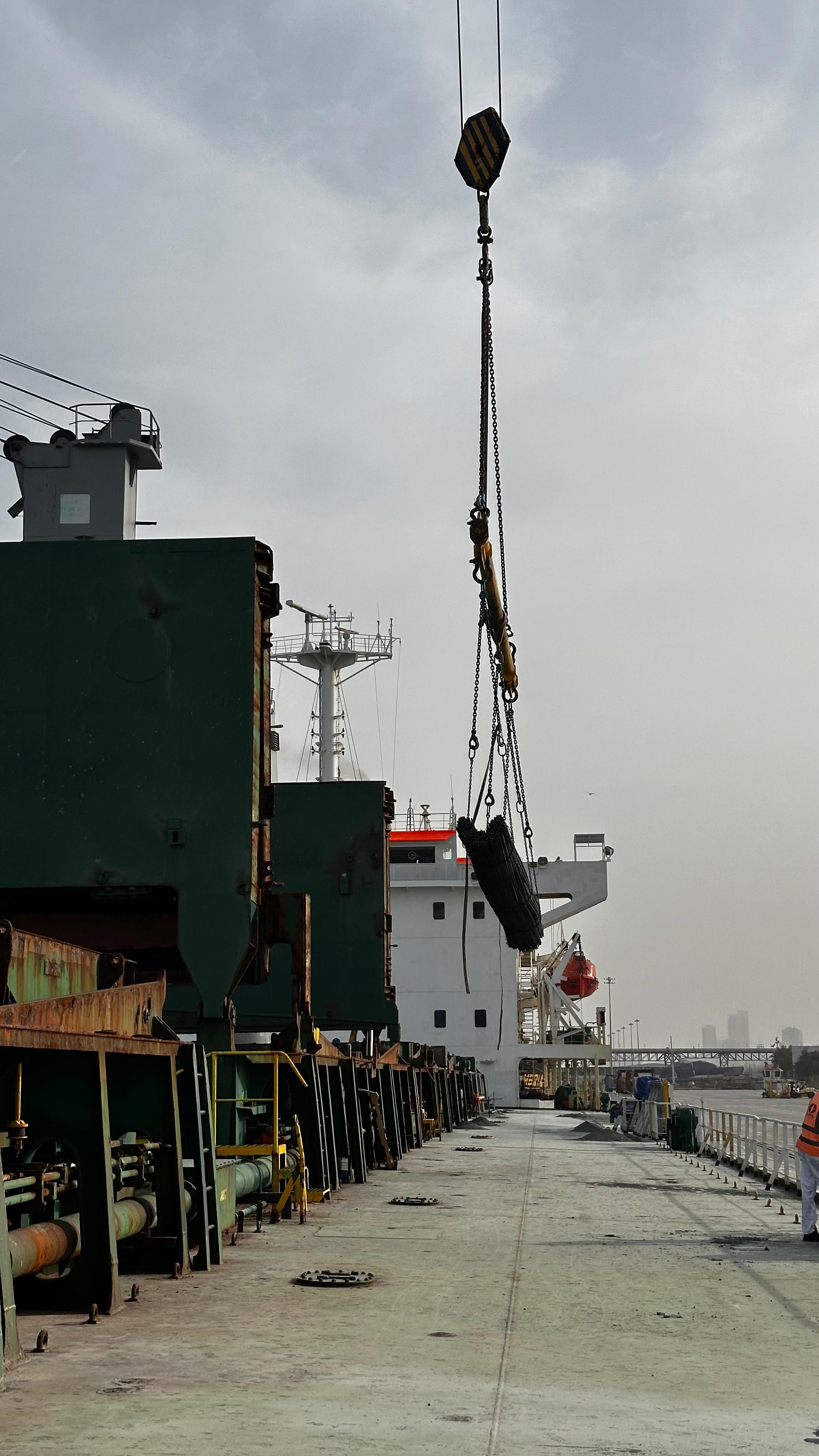 Vessel crane and suspended cargo above the quay
