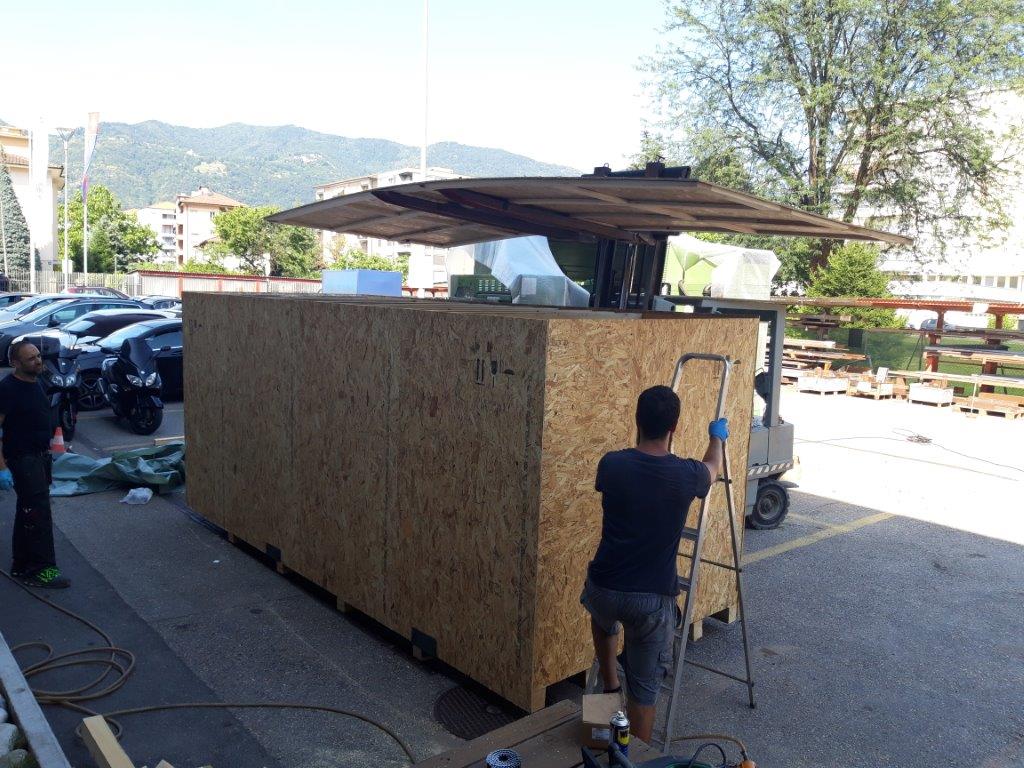 Personnel preparing a large timber crate around industrial cargo