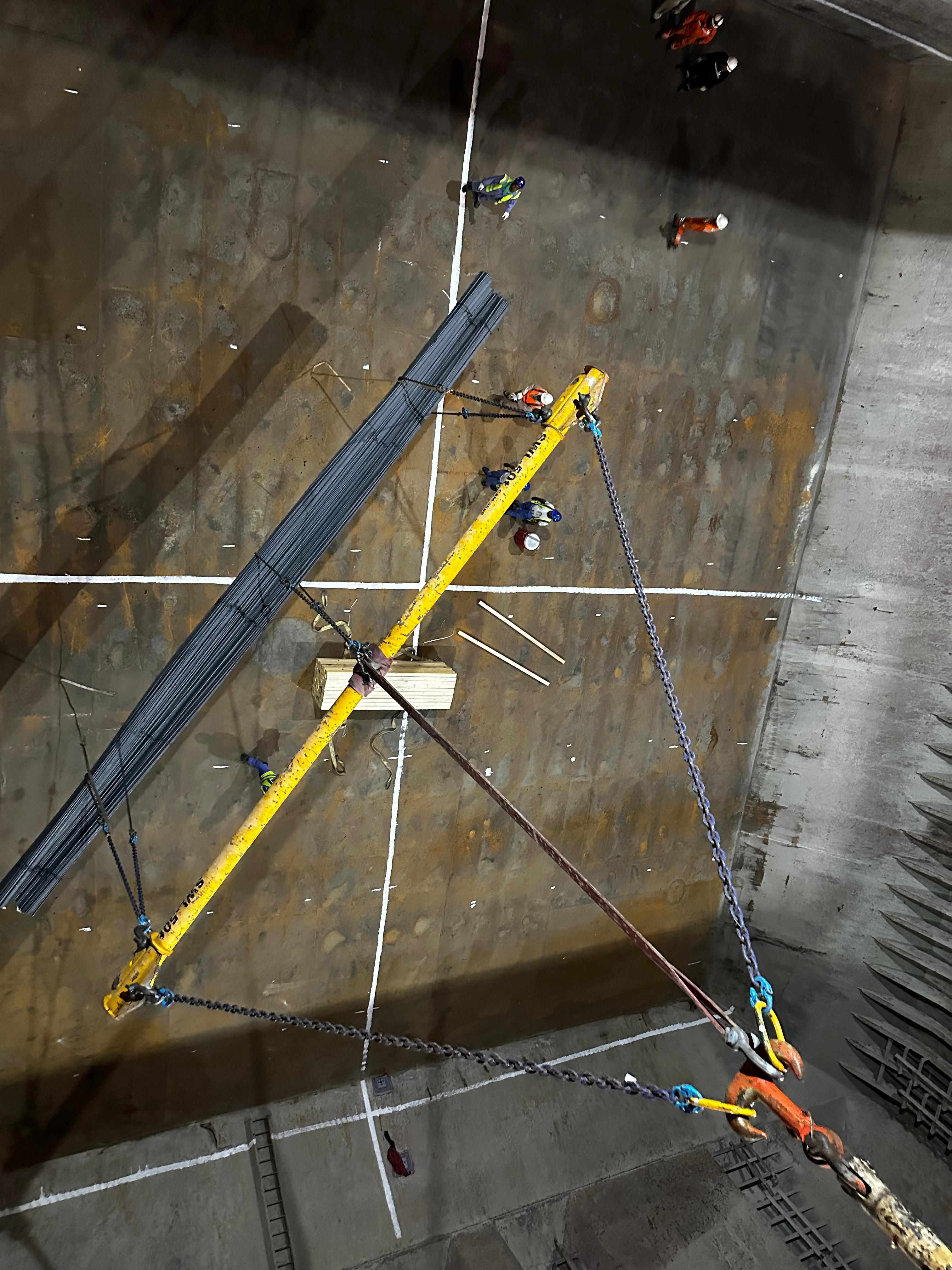 Long steel cargo suspended over the floor of a vessel hold